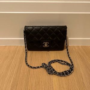 Chanel mini quilted bag with silver clasp front closure and back zipper pocket.